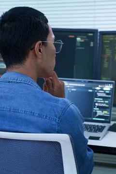Programmer Analyzing Code on Multiple Screens Stockfoto's