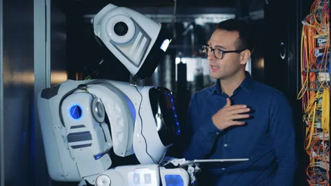 Programmer and a robot work at a data center, close up. Stock Footage 99476091