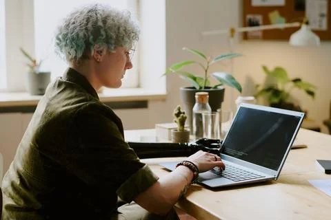 Programmer With Arm Prosthesis Coding In Office Stock Photos