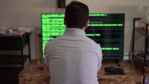 Programmer from behind analyzing hacking software on dual monitors, Stock Footage 345290427