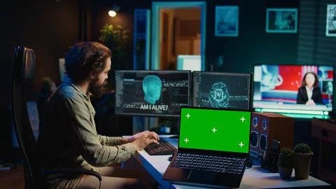 Programmer being asked existential questions by awaken AI, chroma key laptop Stock Photos