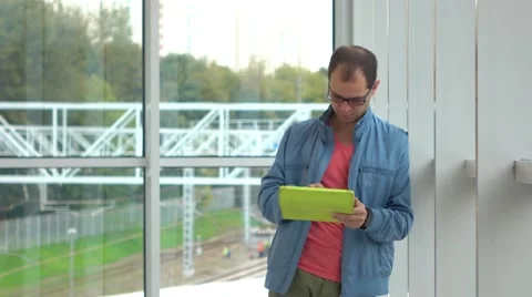 Programmer in black rim glasses using his tablet computer at modern railroad Stock Footage 67640787