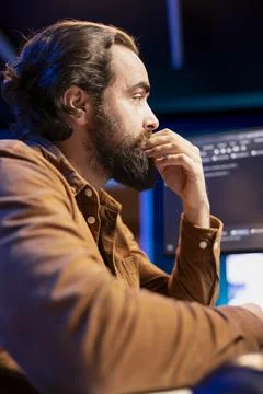 Programmer carefully reading lines of code on desktop PC monitor Stock Photos