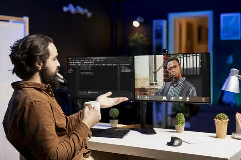 Programmer checking code with colleague in internet videoconference meeting Stock Photos