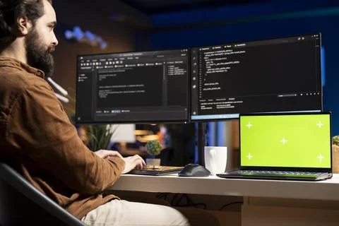 Programmer checking code displayed on computer monitors using mockup notebook Stock Photos
