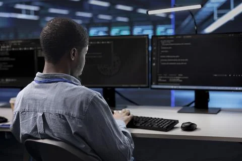 Programmer checking for signs of imminent failure in data center hardware Stock Photos