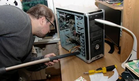 The programmer cleans the desktop computer system unit from dust using a va.. 写真素材
