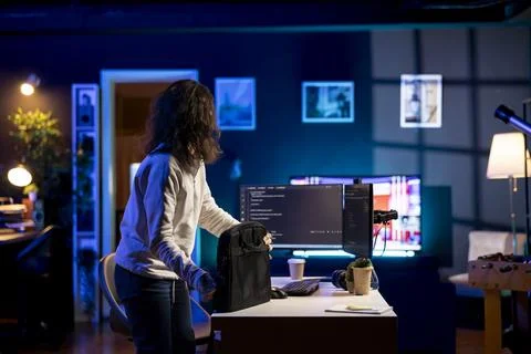 Programmer closing backpack, finishing job shift after preventing malware Stock Photos