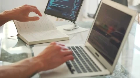 Programmer codes on a laptop and use tablet, focusing on app development. Stock Footage 296223028