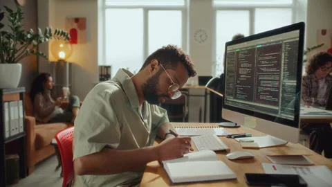 Programmer on Coding on Computer and Taking Notes at Office Workplace Stock Footage 305313315