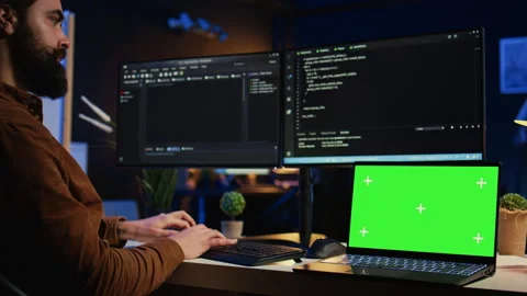 Programmer coding on computer next to isolated screen laptop in home office Stock Footage 265509262