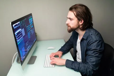 Programmer coding in the computer on office desk Stock Photos