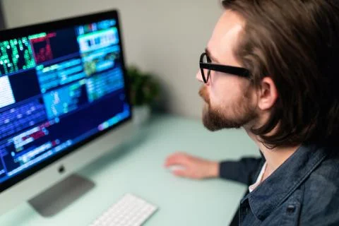 Programmer coding in the computer on office desk Stock Photos