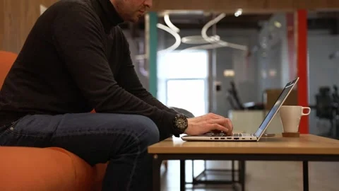 A programmer coding at lap top at coworking space Stock Footage 247853118