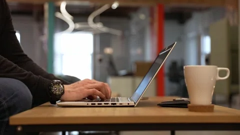 A programmer coding at lap top at coworking space Stock Footage 248004399