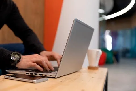 A programmer coding at lap top at coworking space Stock Photos