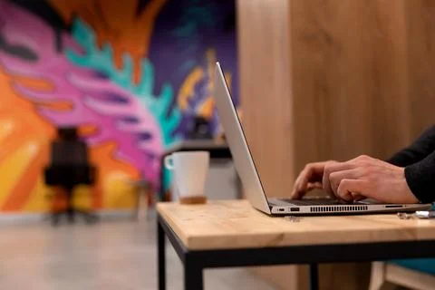 A programmer coding at lap top at coworking space Stock Photos
