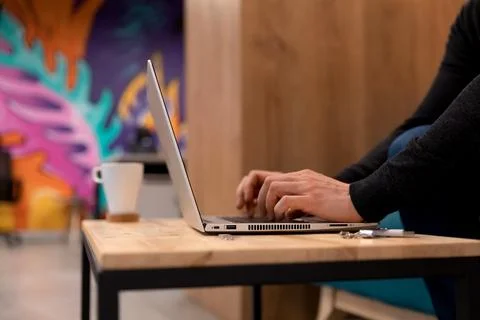A programmer coding at lap top at coworking space Stock Photos