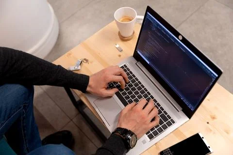 A programmer coding at lap top at coworking space Stock Photos