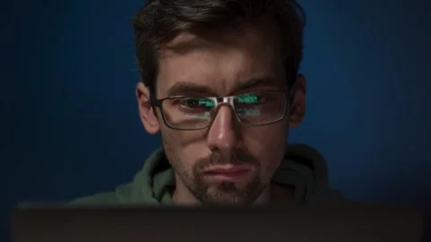 Programmer coding on laptop with focused expression Stock Footage 303998389