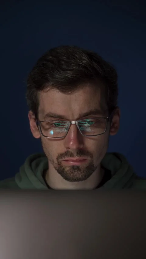 Programmer coding on laptop with focused expression Stock Footage 308016196