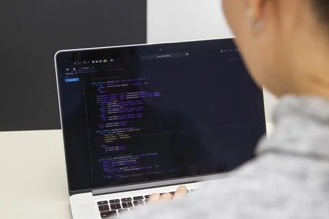 A programmer coding on a laptop in the workplace Stock Photos