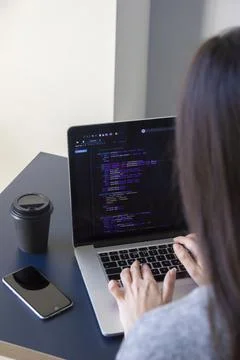 A programmer coding on a laptop in the workplace Stock Photos