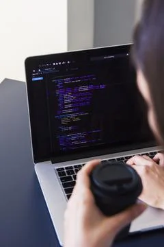 A programmer coding on a laptop in the workplace Stock Photos