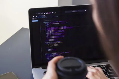 A programmer coding on a laptop in the workplace Stockfoto's