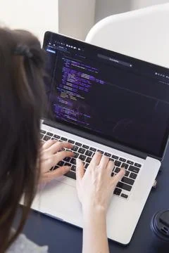 A programmer coding on a laptop in the workplace Stock Photos