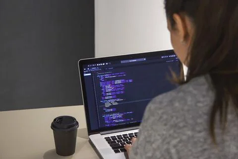 A programmer coding on a laptop in the workplace Stock Photos