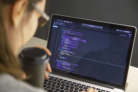 A programmer coding on a laptop in the workplace Stock Photos