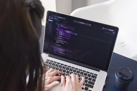 A programmer coding on a laptop in the workplace Stockfoto's