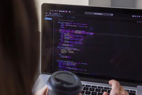 A programmer coding on a laptop in the workplace Stock Photos
