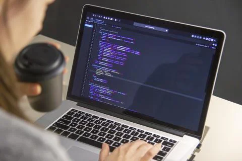 A programmer coding on a laptop in the workplace Stock Photos