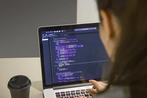 A programmer coding on a laptop in the workplace Foto stock