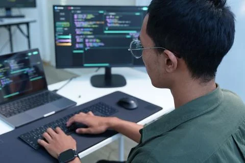 Programmer Coding Software on Computer in Modern Development Workspace 库存照片
