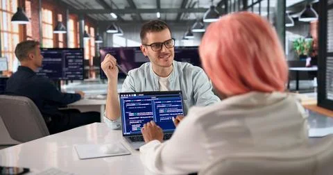 Programmer Collaborates With Diverse Team Coding Software In Modern Office. Foto stock
