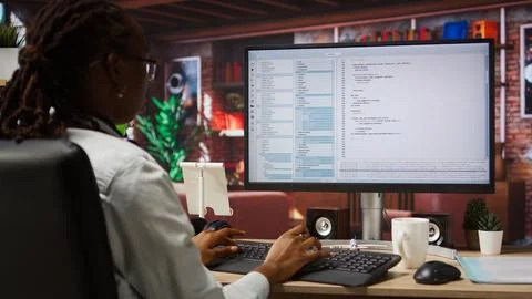 Programmer at computer desk coding, creating software Stock Photos