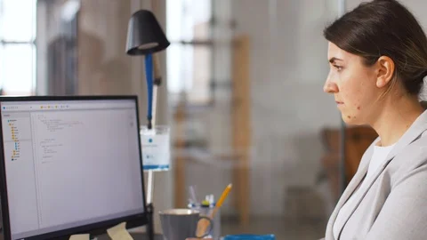 Programmer at computer working and drinking coffee Stock Footage 105030590