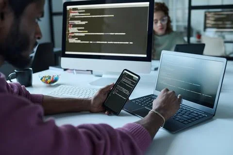 Programmer connecting smartphone with laptop Stock Photos