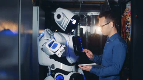 Programmer controls a robot in a server room, close up. Stock Footage 99475105