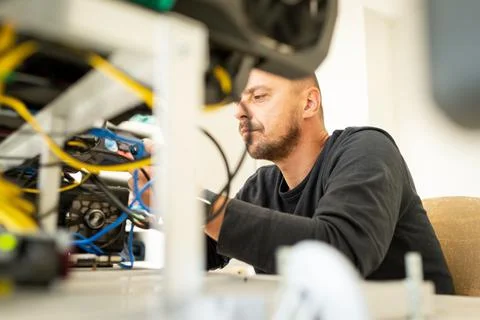 Programmer on cryptocurrency mining rig to optimal operational settings Foto stock