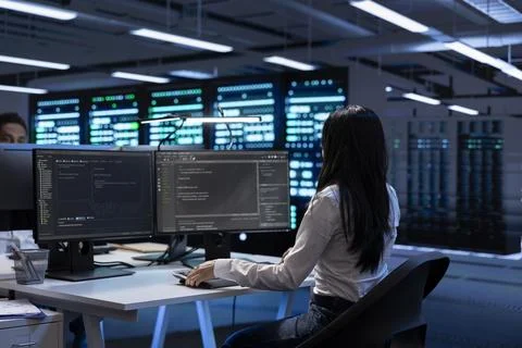 Programmer in data center checking equipment performance on computer Stock Photos