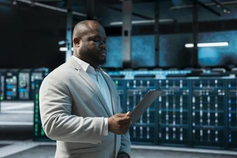 Programmer in data center updating systems using tablet, debugging app Stock Photos