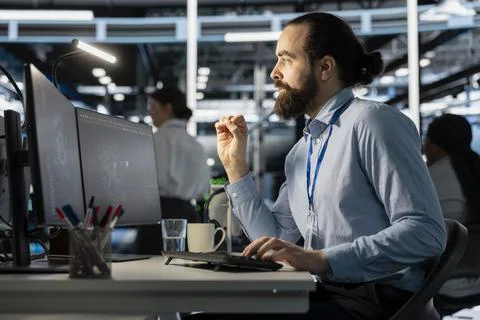 Programmer in data center using computer, doing software updates, Stock Photos