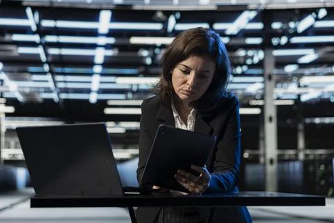 Programmer in data center using devices, applying security patches Stock Photos
