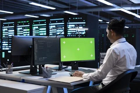 Programmer in data center using green screen computer Stock Photos