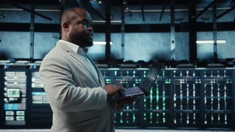 Programmer in data center using laptop, employing AI machine learning models Stock-Footage 311833317