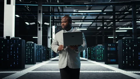 Programmer in data center using laptop, testing equipment failover scenarios Stock Footage 311961858